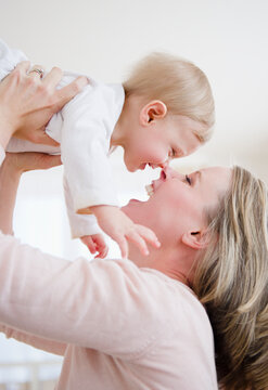 Mother lifting son (6-11 months)