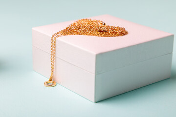 Valentine's Day. Perfume and a box with a chain on a blue background..