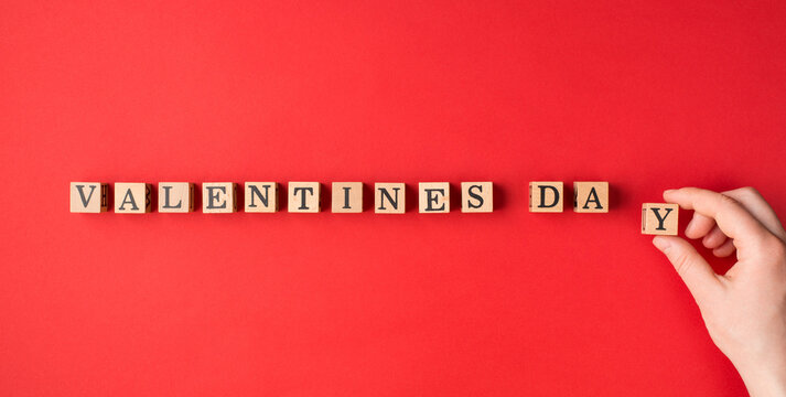 Valentines day expecting concept. Flatlay layout close up view photo of female girl hand putting letters in a line isolated red color bright backdrop