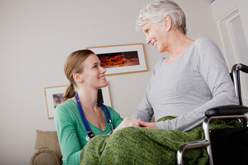 Young female nurse taking care of senior woman