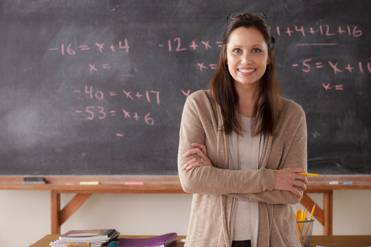 Portrait of teacher with blackboard in background