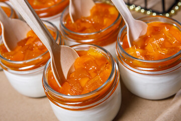 Persimmon and whipped cream smoothie in a glass jar. Wooden spoons in jars.