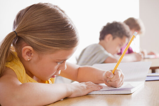 Schoolchildren focused on writing in classroom