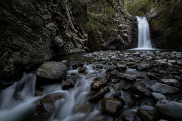 Waterfall splashing and flowing through stones on the river.