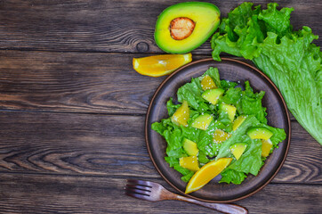 fresh summer homemade salad of vegetables and fruits, orange, lettuce, avocado and sesame seeds, healthy food, organic, vegetarian eco health and immunity products