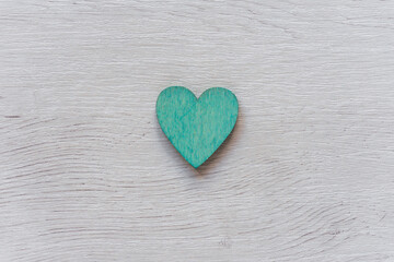 Obraz premium Green heart on wooden table