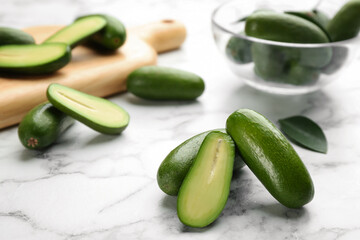 Fresh seedless avocados with green leaves on marble  table