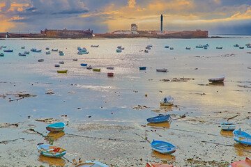Abandoned boats during sunset, landscape on the edge of the Atlantic in Cadiz, Spain