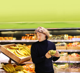 Young man buying vegetables and fruits at the market.