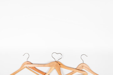 Clothes hangers made of wood on a light background. Hangers made of environmentally friendly material. Space for text