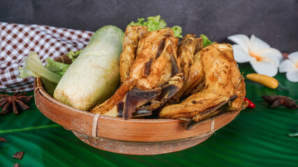 Selective focus - Ayam Goreng Lalapan - chicken classic Indonesian dishes - served with chili sauce, and fresh vegetables in a wicker plate