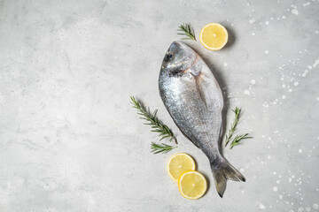 Fresh fish dorado or sea bream with ingredients for cooking  flat lay composition . Healthy food concept. Top view with copy space.