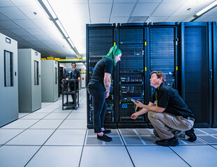 Co-workers talking in data center server room