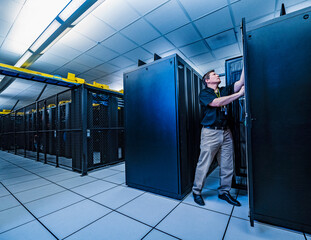 Employee working on server rack in data center