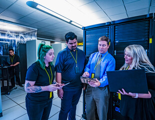 Four co-workers looking at a tablet in data center