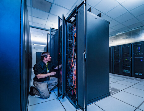 Employee working on server rack in data center