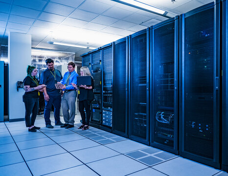 Four co-workers having a meeting in data center