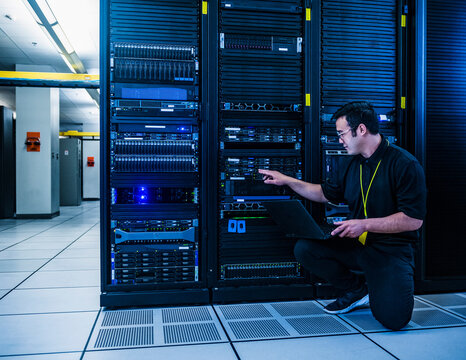 Employee pointing at server rack in data center