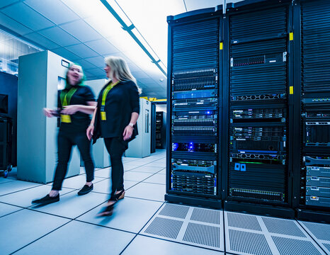 Two co-workers walking together in data center