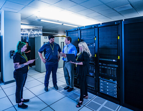 Four co-workers having a meeting in data center
