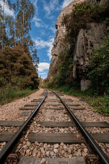 Fototapeta premium Old Railway with rocky mountains and stone walls on a sunny day in Suesca, Cundinamarca - Colombia