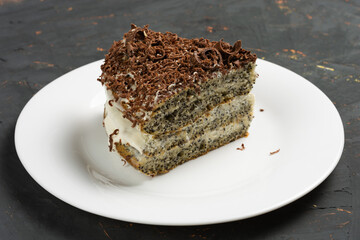 on a white plate cake sprinkled with grated pieces of chocolate on top. birthday holidays, dessert.