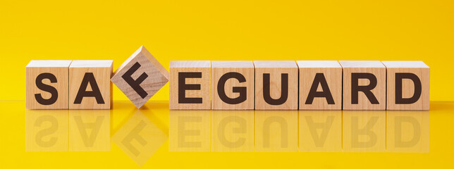 safeguard word is made of wooden building blocks lying on the yellow table, concept