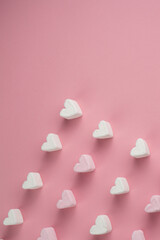 Heart shaped marshmallows are placed in rows at the bottom of the pink background with space to write your text.