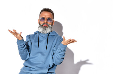 Annoyed emotional grey-haired bearded man in trendy sunglasses, casual sweatshirt looking at camera with irritated look. People, negative emotions and feelings. Studio shot isolated on white