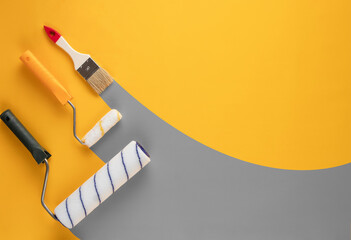 Gray stripes of paint from rollers and brushe on a yellow background.