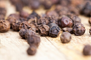 spice black pepper scattered on an old wooden table