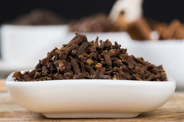 spices of cloves scattered on an old wooden table