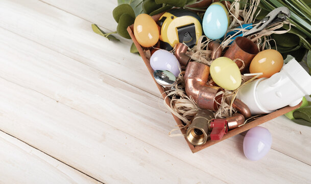 Easter Egg and plumbing tools, copper pipes and fittings. Holiday plumber. Top view. copy space.