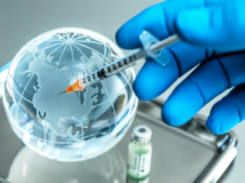 Mature male doctor injecting planet earth in hospital during COVID-19