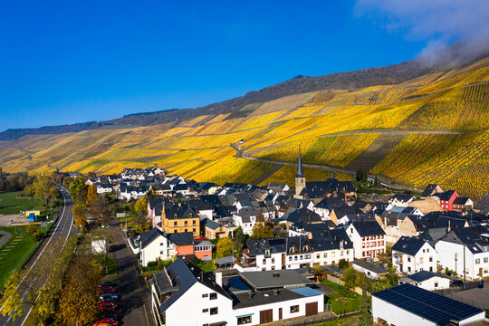 Germany, Rhineland-Palatinate, Bernkastel-Kues, Helicopter view of rural town in autumn with hillside vineyards in background