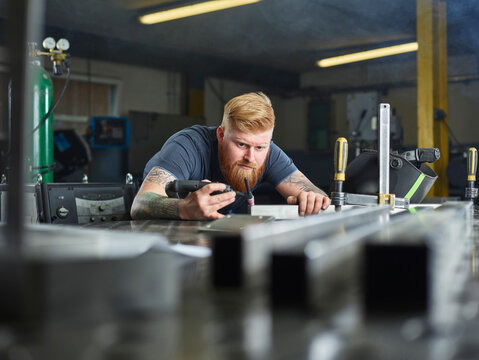 Metal technician checking seam material while working at industry