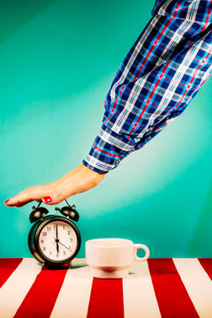 Arm of woman turning off old-fashioned alarm clock