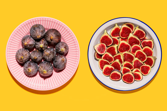 Studio shot of two plates with halved and whole figs