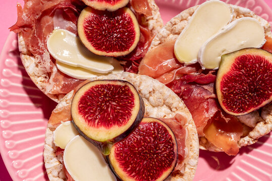 Rice cakes with serrano ham, cheese and fig slices