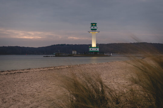 Germany, Schleswig-Holstein, Friedrichsort, Sandy coastal beach at dawn with lighthouse in background