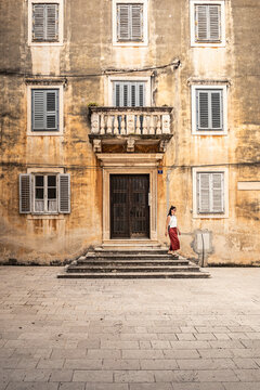 Woman descending steps at old building
