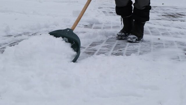 The janitorThe janitor cleans the snow with a plastic shovel cleans the snow with a plastic shovel