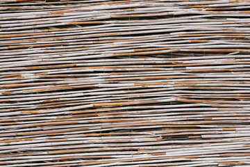 Close-up texture of a fence made of bamboo twigs.