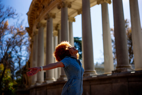 Mid adult woman with arms outstretched standing at Parque Del Buen Retiro, Parque Del Buen Retiro, Spain