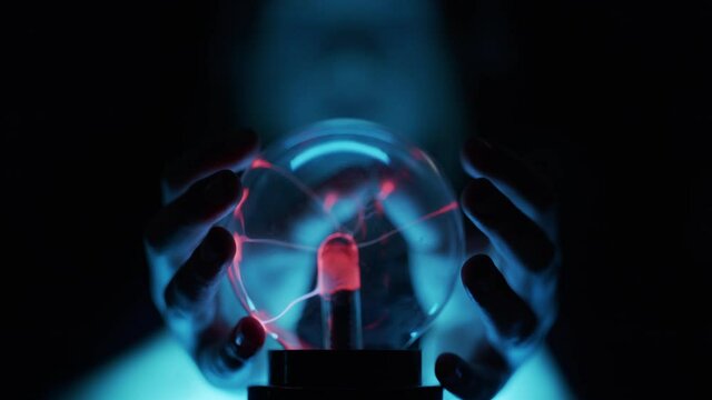 Girl'S Hands Closing Around Plasma Globe