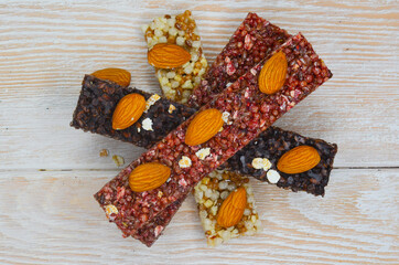 set of oatmeal, buckwheat and rice cereal bars on wooden table, protein sports food for weight control