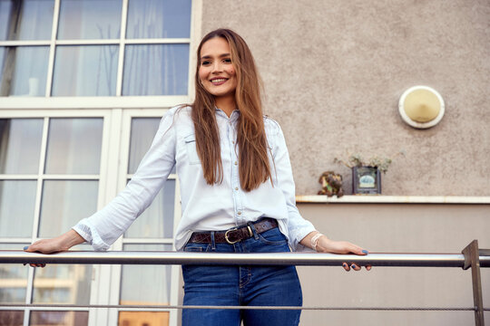 Business woman wearing casual smiling while standing in balcony