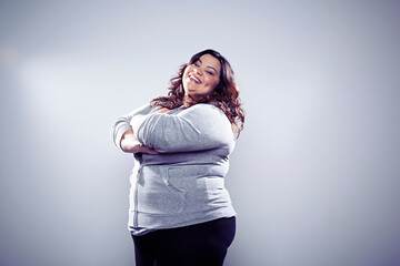 Mid adult woman wearing grey tracksuit top, arms crossed