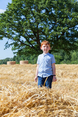 Naklejka na ściany i meble a boy with red hair walks in a field