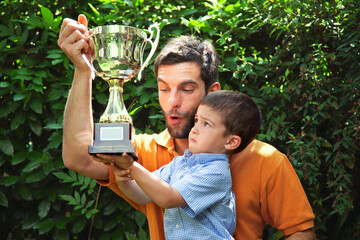 Father and son holding trophy